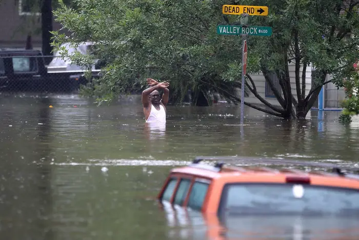 A man waves down a rescue crew as he tries to leave the area after it was inundated with flooding from Hurricane Harvey on August 28, 2017 in Houston, Texas<br>